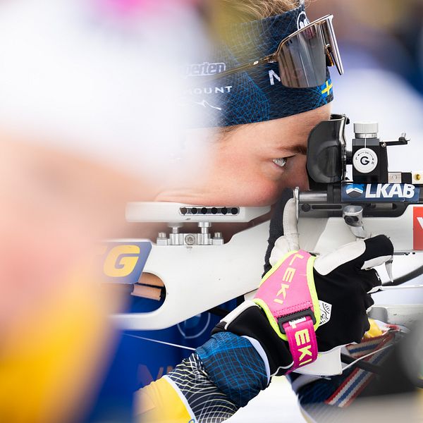 Hanna Öberg siktar med gevär under världscuptävling i skidskytte.