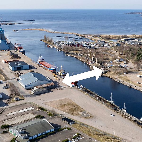 Flygbild över en hamnen och Nissans utlopp i Halmstad med en vit pil som visar vara den nya Söderbron ska byggas.