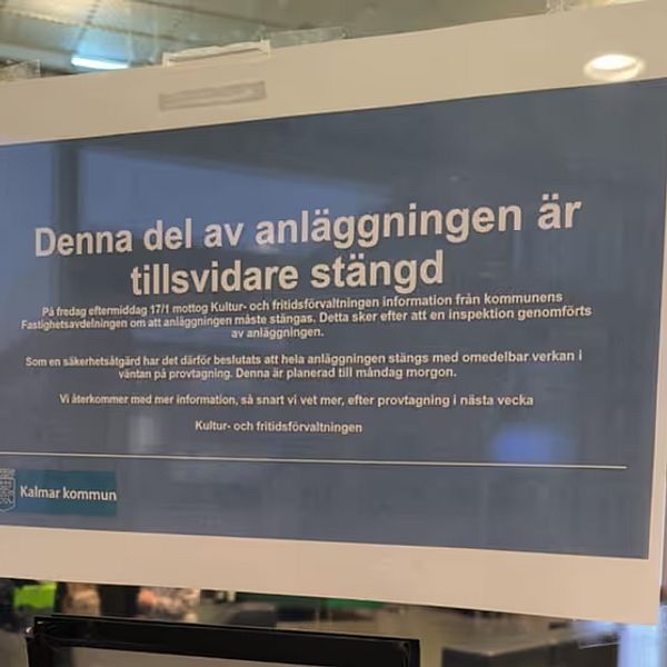 Skylt som informerar om att hela Äventyrsbadet i Kalmar tillfälligt är stängd. Skylten är placerad i en offentlig miljö med moderna inslag.