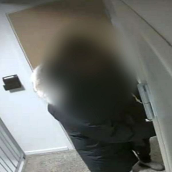 Två personer fotograferade av en hemlig kamera, går in i en lägenhet.
