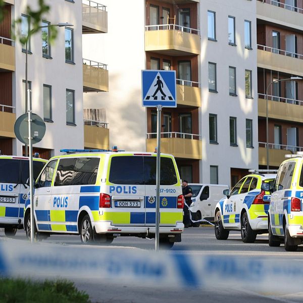 Flera polisbilar framför bostadshus i Bredäng