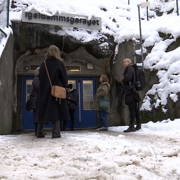 Personer utanför skyddsrummet i garaget på Kungsholmen inför regeringens pressträff.