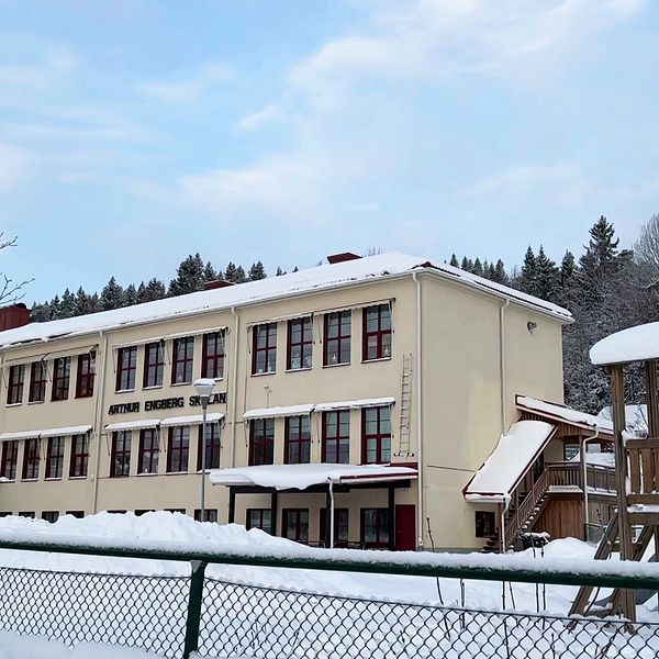 Arthur Engbergskolan i Hassela vintertid med snö på marken och lekplats i förgrunden.