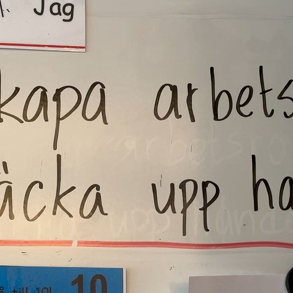 Skylt med texten ”Skapa arbetsro. Räcka upp handen” i klassrum