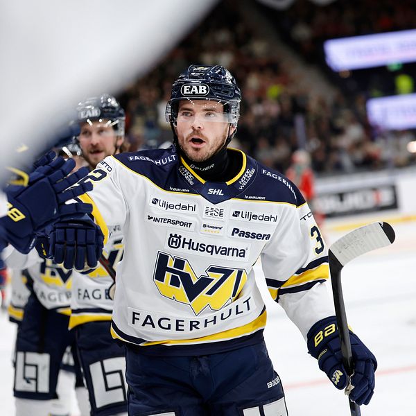Ishockeyspelare från HV71 firar på isen under en match med lagkamrater.