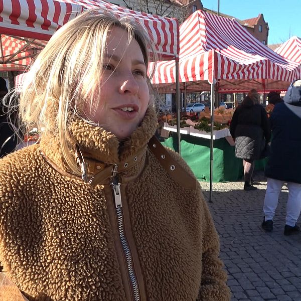 Person i brun jacka på matmarknaden på Möllevångstorget.