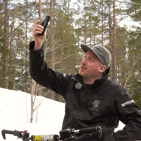 Thomas Ahlm från Naggen håller upp mobiltelefonen i luften för att se om han har mobiltäckning.