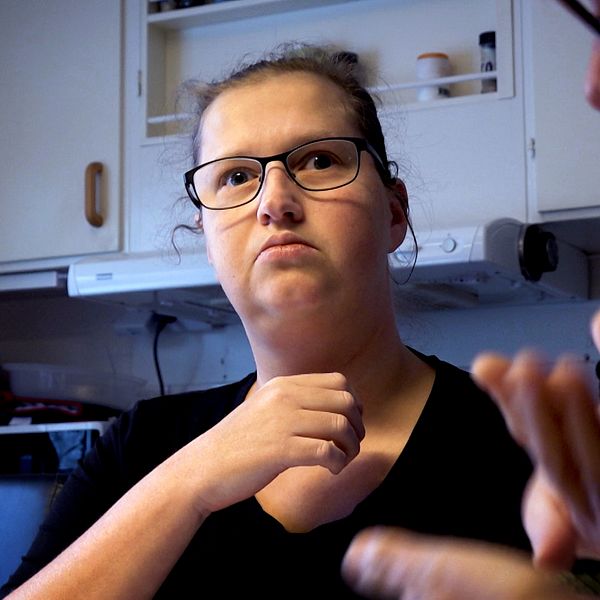 Dövblinda Evelina Lindberg i Piteå kämpar för att få rätt till taktil teckentolk. Kommunen har beslutat att dra in den tjänsten. Kvinna i ett kök.