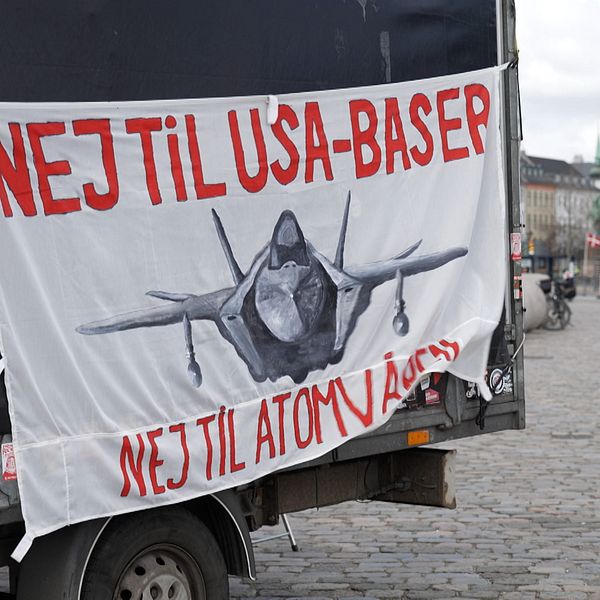 Banderoll med texten ”Nej til USA-baser, nej til atomvåben” och bild på ett militärflygplan.