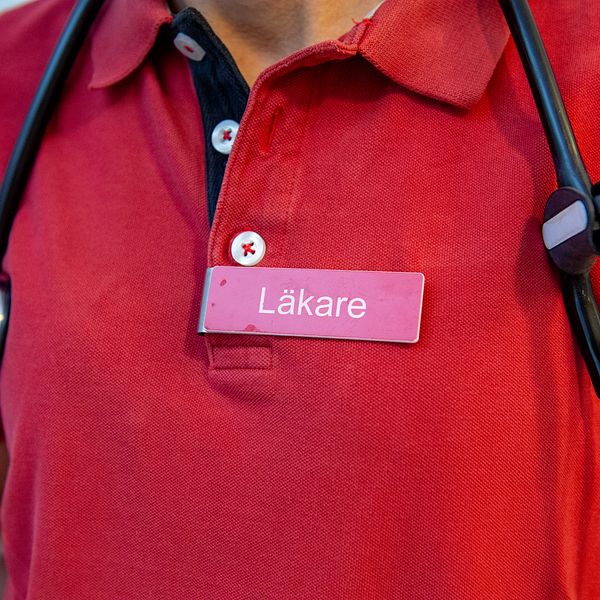 Stetoskop och en namnskylt där det står Läkare på en kvinna.