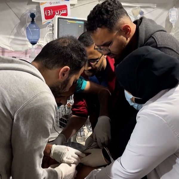 Flera personer hjälps åt att behandla patient på sjukhus i Gaza
