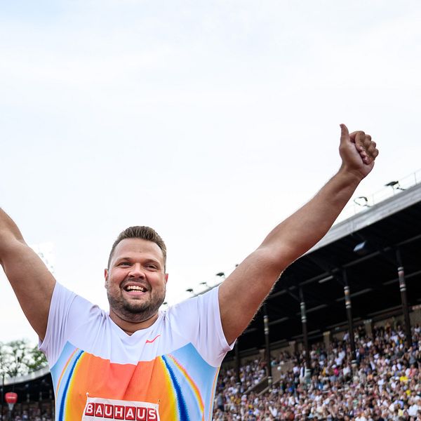 Daniel Ståhl firar med armarna i luften inför publik under Diamond League-tävling.