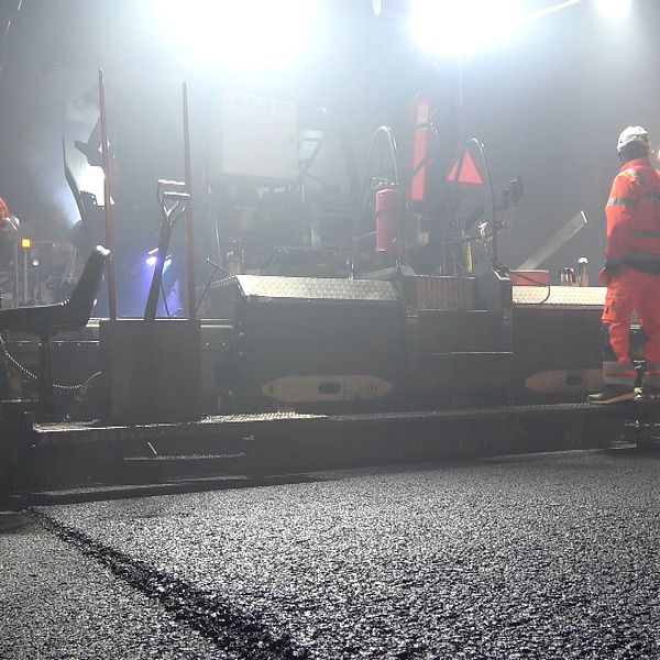 Arbetare lägger asfalt i Förbifart Stockholm-tunneln nattetid