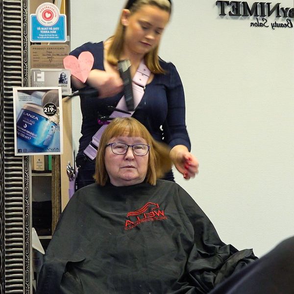 En kvinna sitter i en frisörstol