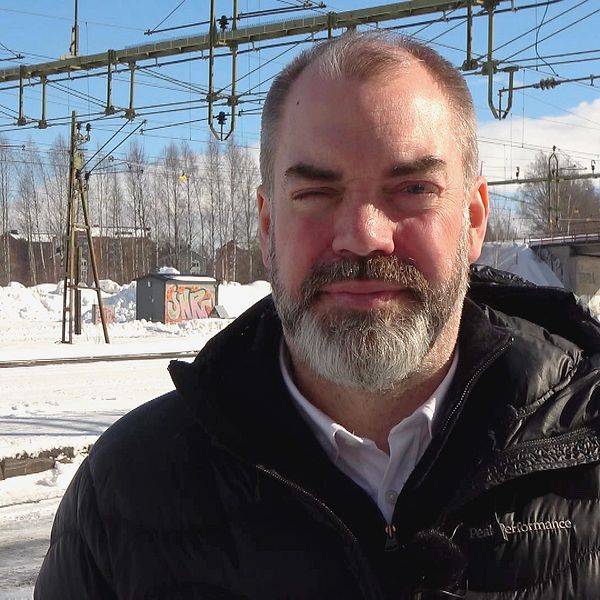 Distriktsordförande för Socialdemokraterna Norrbotten, står vid tågspåret och berättar om deras förslag om dubbelspår efter hela malmbanan