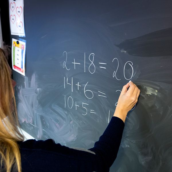 elev som skriver mattetal på svarta tavlan