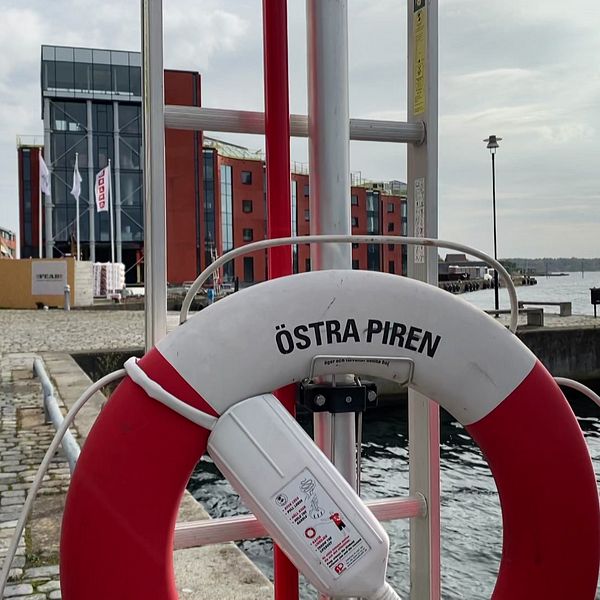 En livboj med texten Östra Piren och en kaj i bakgrunden