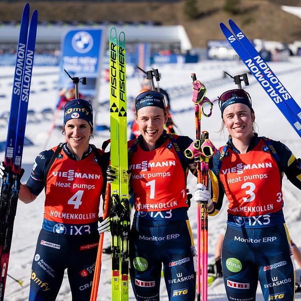 Tre skidskyttar poserar med skidor efter tävling, Hanna Öberg är en av dem.