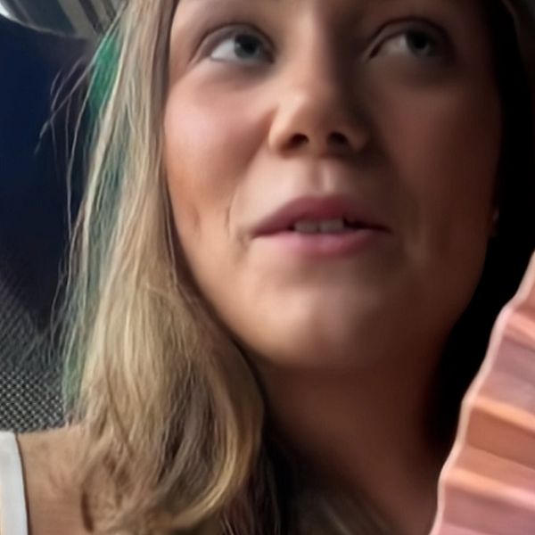 Maja Hilding sitter på tåget på väg till Stockholm med en solfjäder i handen.