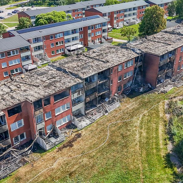 Brandskadat flerfamiljshus med utbränt tak efter matlagningsbrand