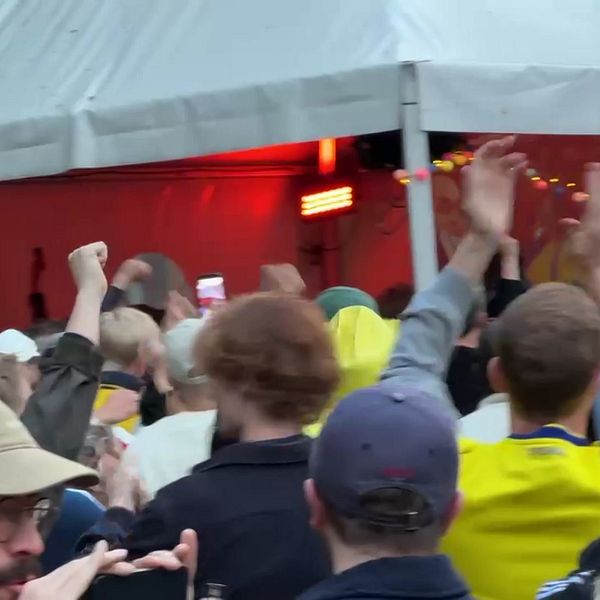 Publik firar fotbolls-VM på en fullsatt bar med höjda armar