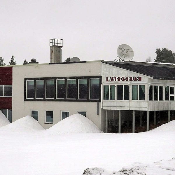En stor vit byggnad omgiven av ett snötäckte.