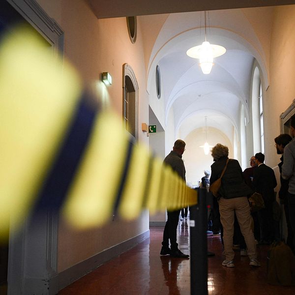Tomas Thorén i en korridor med avspärrningsband och flera personer i bakgrunden