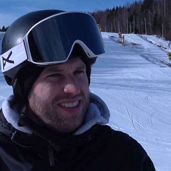 Joakim Bergdahl med skidhjälm i pisten, omgiven av snö och skog i bakgrunden.