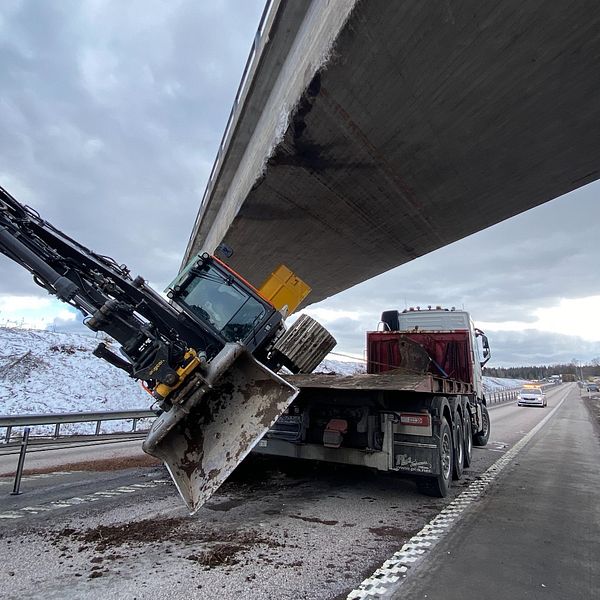 Lastbil med kran har kört in i bro på snöig motorväg.