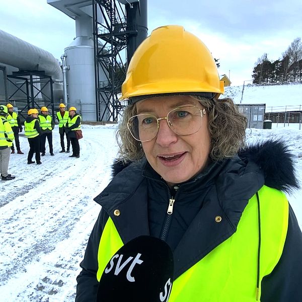 kvinna i varselväst och gul hjälm