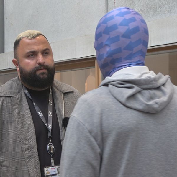 Två personer pratar i en korridor, en taggare i Lund intervjuas om graffiti.