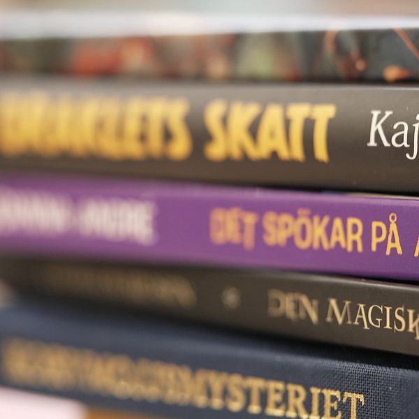 Närbild på en stapel böcker för barn och unga med titlarna synliga på bokryggarna.