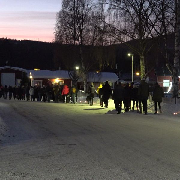 Elever går på led. Marschaller lyser upp vägen i Sveg.