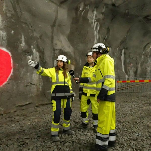 Arbetare i skyddskläder inspekterar tunnelbanebygget i Stockholm under jord