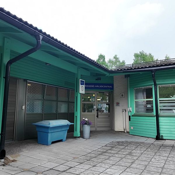 Exteriörbild på Mariehems hälsocentral i Umeå. Vitt tegel och grön träfasad.