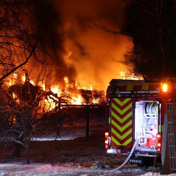 Villa i lågor. Brandbil står bredvid