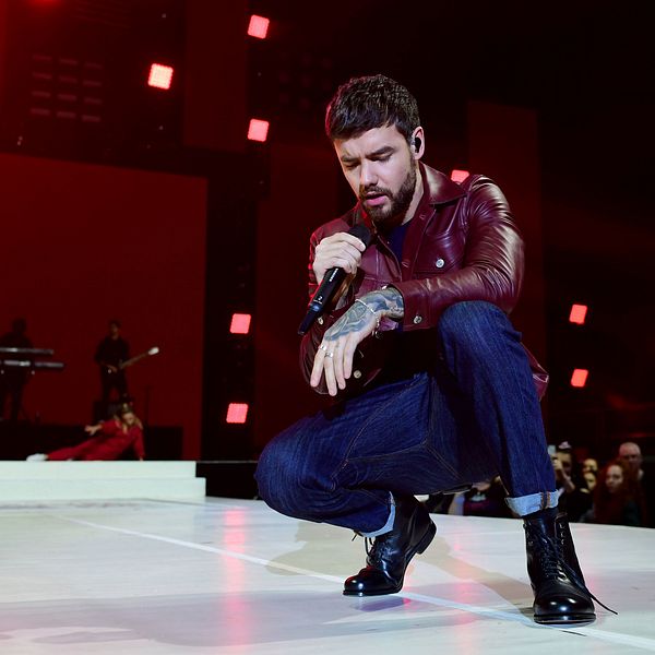 Liam Payne på en scen, hållandes en mikrofon.