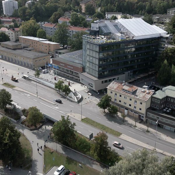 Luftbild av en del av Nyköpingsvägen i Södertälje. Med stadsmiljö med modern byggnad och grönområden i bakgrunden.