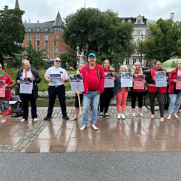 Representanter från fackförbundet Kommunal och busschaufförer manifesterar barfota.