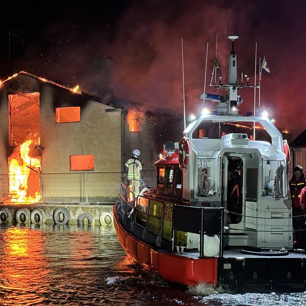 Sjöräddningssällskapet i Strömstad framför en brinnande lokal.