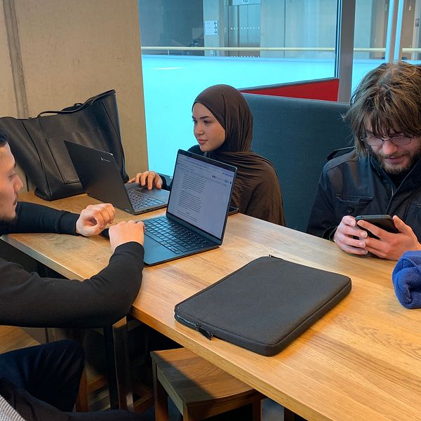Tre elever med dator.