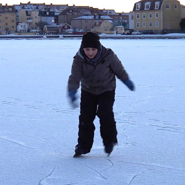 Pojke på snötäckt is.