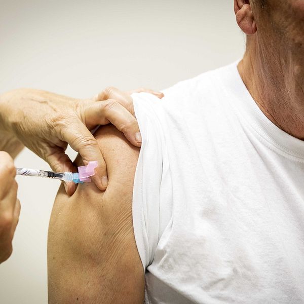 Äldre man får vaccination mot covid 19.