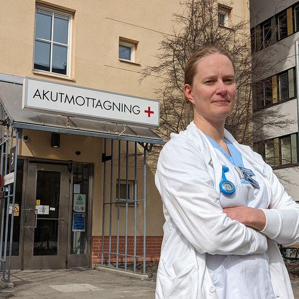 Johanna Sundesten i vita vårdkläder framför akutmottagningens ingång i Umeå.