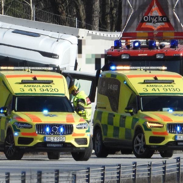 Ambulanser och brandbil vid en lastbil på motorväg.