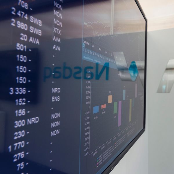 Handelsskärm på Nasdaq-börs visar aktiekurser och grafer.