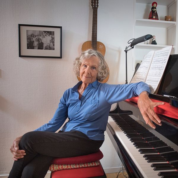 Gullan Bornemark sitter vid ett piano i sitt hem