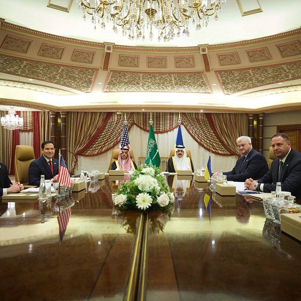 Möte i elegant konferensrum med representanter från USA och Saudiarabien.