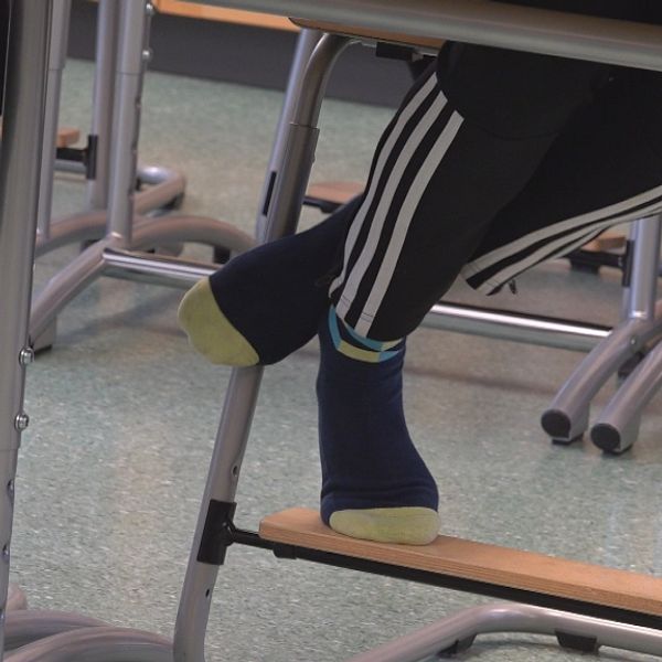 En bild på ben under en skolbänk.