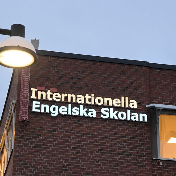 En bild på ett hus med skylten internationella engelska skolan i kvällsljus